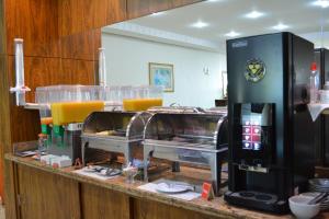 乌贝兰迪亚Sara Palace Hotel的厨房配有带橙汁杯的吧台