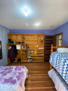 新彼得罗波利斯Chácara paraíso dá paz的一间卧室设有两张床和木制橱柜。