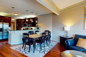 德斯坦Beach Pointe 301的厨房以及带桌椅的起居室。
