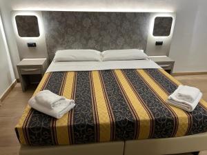 罗马Hotel principe的一间卧室配有一张大床和两条毛巾
