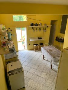 伦索伊斯Quinca’s Hostel的厨房设有黄色的墙壁和桌子