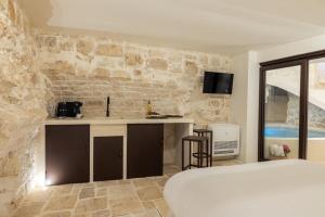 奥斯图尼Suite Le Grotte的一间卧室设有一张床和石墙