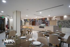 达曼Mena East Suites Dammam的餐厅内带桌椅的用餐室