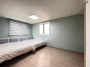 首尔Twin Rabbit Guesthouse的一间卧室设有一张床和一个窗口