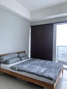 雅加达Studio Apartment at Puri Mansion West Jakarta的一间卧室设有一张大床和大窗户