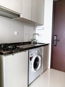 雅加达Studio Apartment at Puri Mansion West Jakarta的厨房配有洗衣机和水槽