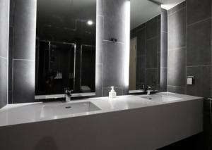 釜山H Avenue Hwamyeong的一间带两个盥洗盆和大镜子的浴室