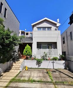 东京Bell house的前面有车道的大型白色房屋