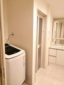 东京Bell house的客房内的厨房配有洗衣机