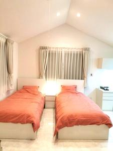 东京Bell house的一间卧室配有两张带橙色床单的床