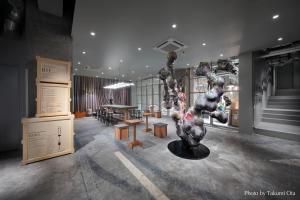 东京KAIKA TOKYO by THE SHARE HOTELS的一间房间,里面设有一张桌子和雕塑
