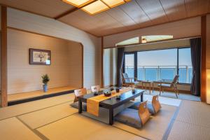 函馆伊美吉酒店及度假村的客厅配有桌椅,享有海景