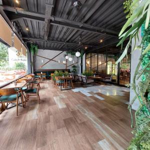 雅加达3 Point Syariah Residence的餐厅设有木桌和椅子,种有植物