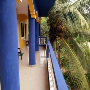 曼德姆PARVATI MANDREM的阳台,阳台有蓝色的柱子和棕榈树