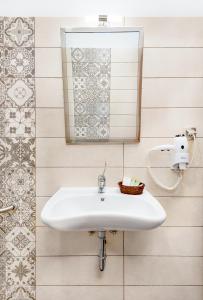 Chrysohorafa里姆奈奥旅馆的浴室设有白色水槽和镜子
