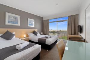 斯卡曼德Scamander Beach Resort的酒店客房设有两张床和一个阳台。