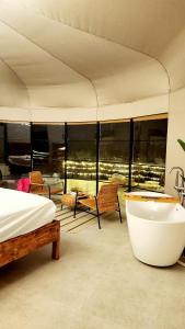 BadīyahStarry Domes Desert Camp的一间带浴缸和床的卧室以及一个阳台