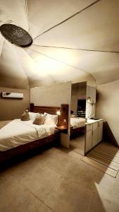 BadīyahStarry Domes Desert Camp的大房间设有两张床和天花板