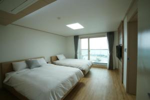 济州市The Beach Pension的酒店客房设有两张床和窗户。