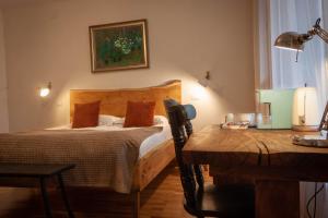 阿尔巴尤利亚Elma Guesthouse的一间卧室配有一张床和一张带台灯的桌子