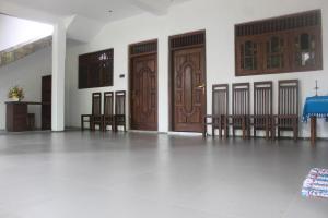阿努拉德普勒Eleven11 Resort的一间设有三扇木门和一张桌子及椅子的房间