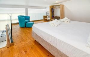 马莱迈Cocoon Luxury Villas的一间卧室配有一张大床和一张蓝色椅子