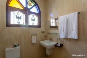 桑给巴尔阿尔米纳尔酒店的一间带水槽和卫生间的浴室以及窗户。