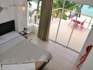 长滩岛Signature Boracay South Beach的一间卧室配有一张床,享有海滩美景