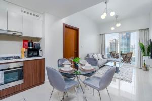 迪拜Delightful 2BR apartment at Reva Residences的厨房以及带桌椅的起居室。