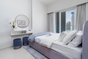 迪拜Delightful 2BR apartment at Reva Residences的一间卧室配有一张带窗户和镜子的床