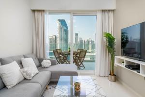 迪拜Delightful 2BR apartment at Reva Residences的带沙发和大窗户的客厅