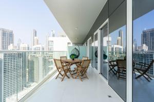 迪拜Delightful 2BR apartment at Reva Residences的大楼顶层阳台配有桌椅