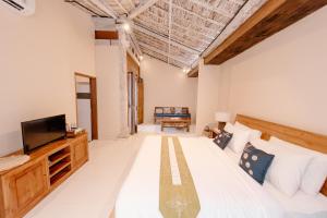 塞米亚克Moson Villa Legian的一间卧室配有一张大床和电视