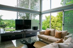班康卡臣泰国强山度假屋的客厅配有平面电视和大窗户。