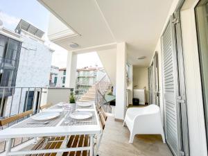 皮内托Homiday - Residenza Caravelle的阳台配有白色的桌椅。