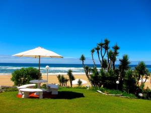 维德尼斯东街之家海滩旅馆的海滩上配有遮阳伞和桌椅