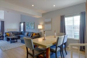 海沃德@ Marbella Lane - 4BR City Escape in Hayward的客厅配有桌子和蓝色沙发