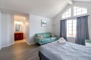 海沃德@ Marbella Lane - 4BR City Escape in Hayward的一间卧室配有一张床、一张沙发和一个窗口