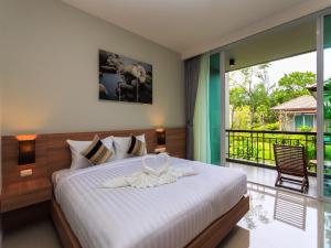 蔻立奥勒森林度假酒店的一间带大床的卧室和一个阳台