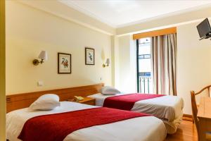丰沙尔科伦坡公寓的酒店客房设有两张床和窗户。