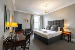 爱丁堡弗雷德里克街53号酒店的一间卧室配有一张大床、一张桌子和一张书桌