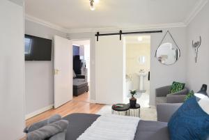 开普敦Flatlet 2.1km from Iconic Blaauwberg Beach的一间带灰色沙发的客厅和一间客厅