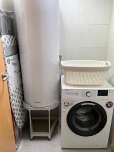 巴塞罗那Standing Apartment Barcelona Forum的洗衣机上方有一个篮子