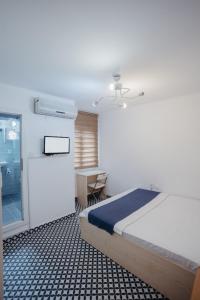 伊兹密尔Deniz Pansiyon的一间卧室配有一张床、一张书桌和一个窗户。