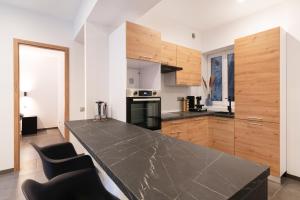 JarnyLE 23的厨房配有黑色台面和木制橱柜