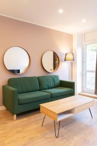 JarnyLE 23的客厅配有绿色沙发和两面镜子