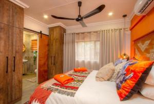 玛洛斯帕克Kaya KaBush的一间卧室配有一张带橙色枕头的大床
