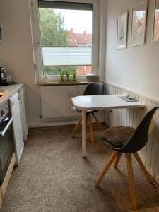 埃姆登Ferienwohnung Engelke的厨房配有桌椅和窗户。