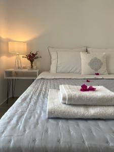 德里奥斯Alexander Suites的一张白色的床,上面有两条毛巾