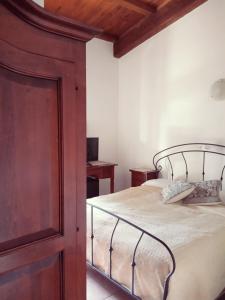 TulaAgriturismo Pedru Caddu的一间卧室配有一张大床和一个木制橱柜